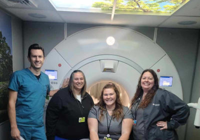MRI care team at Mankato Clinic stand in front of a an MRI machine