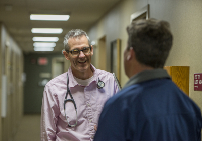 Photo showing Mankato Clinic doctor , smiling, speaking to a man.